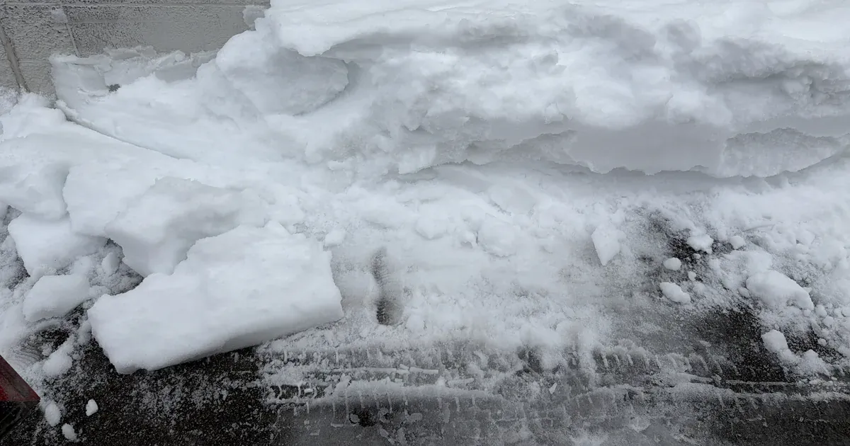 A large pushed-back pile of snow at the edge of a lot